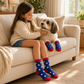 Mellow Monkey matching blue star print socks for a young girl and her small dog sitting together on a beige sofa