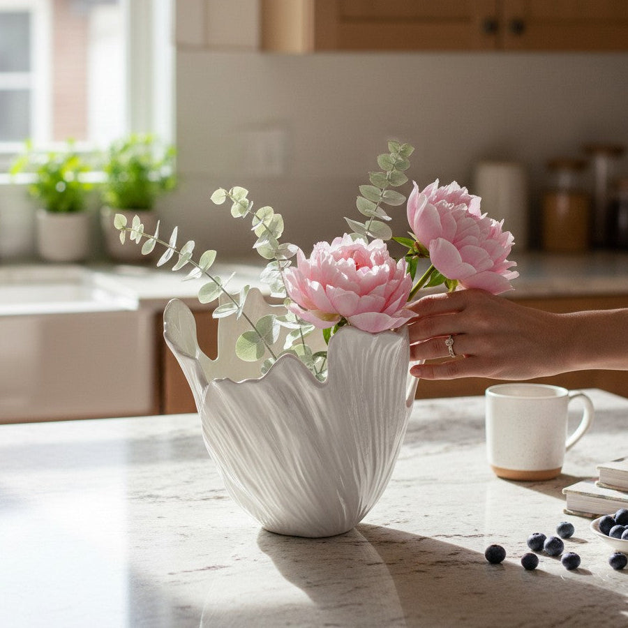 Mellow Monkey handcrafted matte white ceramic iceberg vase with pink peonies on a kitchen countertop
