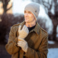 Mellow Monkey men wearing beige moss stitch knit gloves and matching beanie outdoors in a winter coat