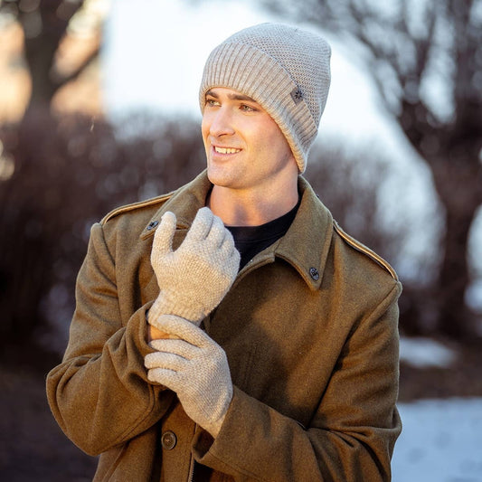 Mellow Monkey men wearing beige moss stitch knit gloves and matching beanie outdoors in a winter coat