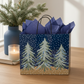 Mellow Monkey large gift bag with midnight snowfall and pine tree print, featuring dark blue tissue paper.