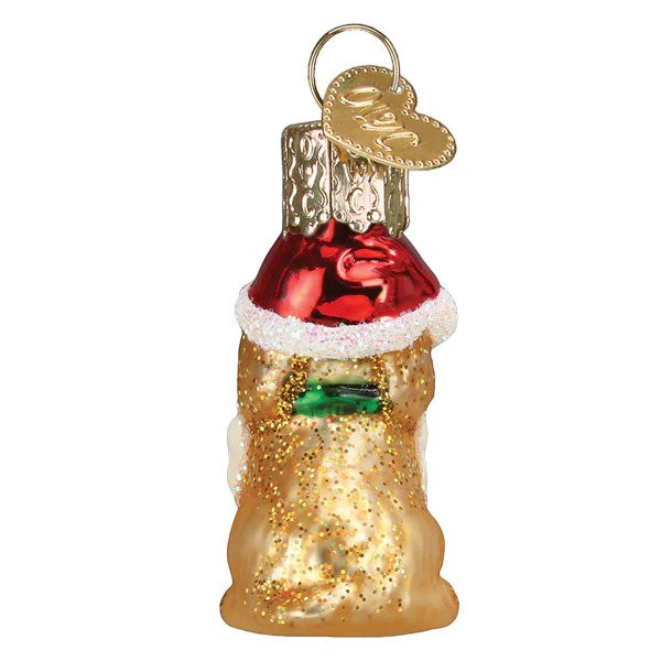 Mellow Monkey Mini Jolly Pup glass ornament with red Santa hat and gold glitter body, holding a green gift.