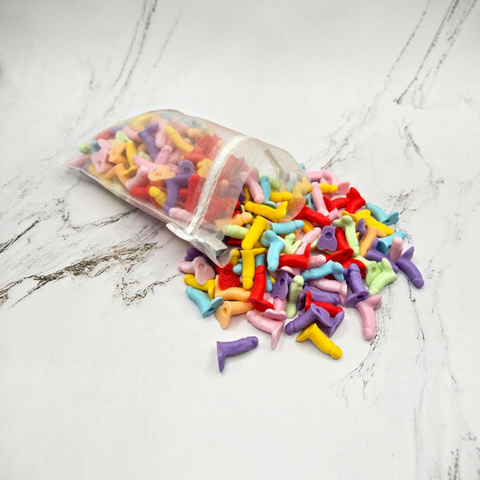 Mellow Monkey assorted colorful 3D printed novelty mini penis figurines spilled from a sheer white drawstring bag.