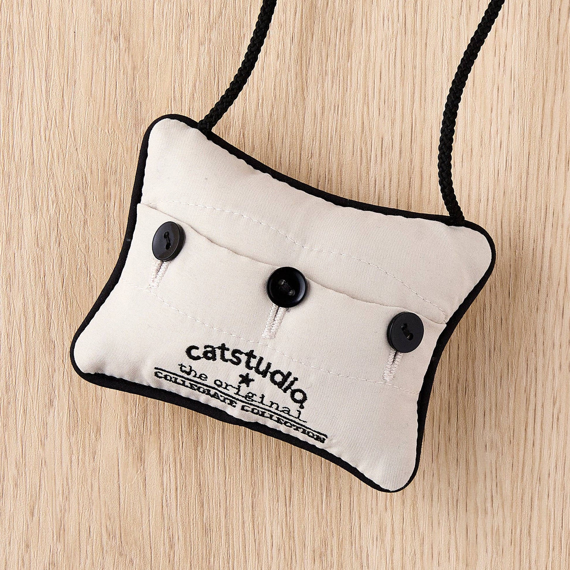 Mellow Monkey University of Connecticut mini pillow ornament with black buttons and hanging cord on wood background