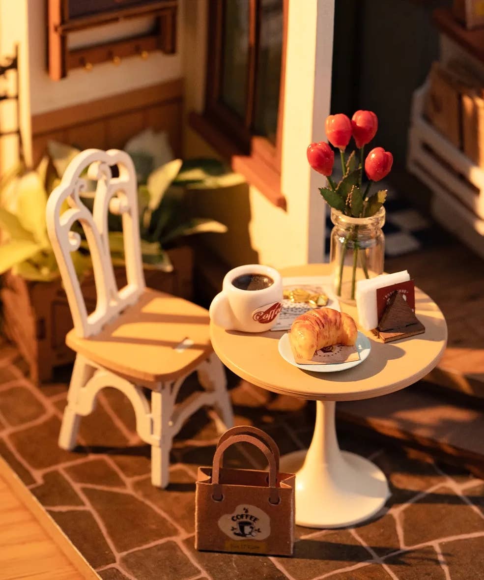 Mellow Monkey Slow Life Café DIY miniature house kit featuring a tiny bistro table, chair, croissant, and coffee cup.