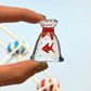 Mellow Monkey 1-inch miniature glass figurine of a red goldfish inside a clear glass bag with a red tie
