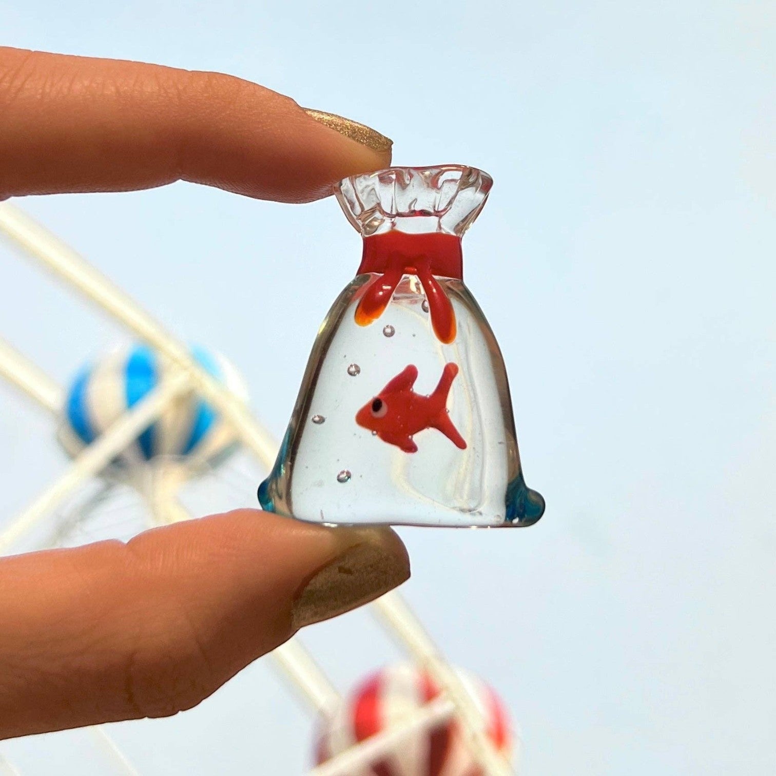 Mellow Monkey 1-inch miniature glass figurine of a red goldfish inside a clear glass bag with a red tie