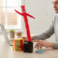 Mellow Monkey miniature red Wacky Waving Inflatable Tube Guy dancing on a desk next to a laptop and mini book.