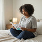 Mellow Monkey Mommy Loves Wine hardcover book with whimsical illustrations, held by a woman sitting on a bed.