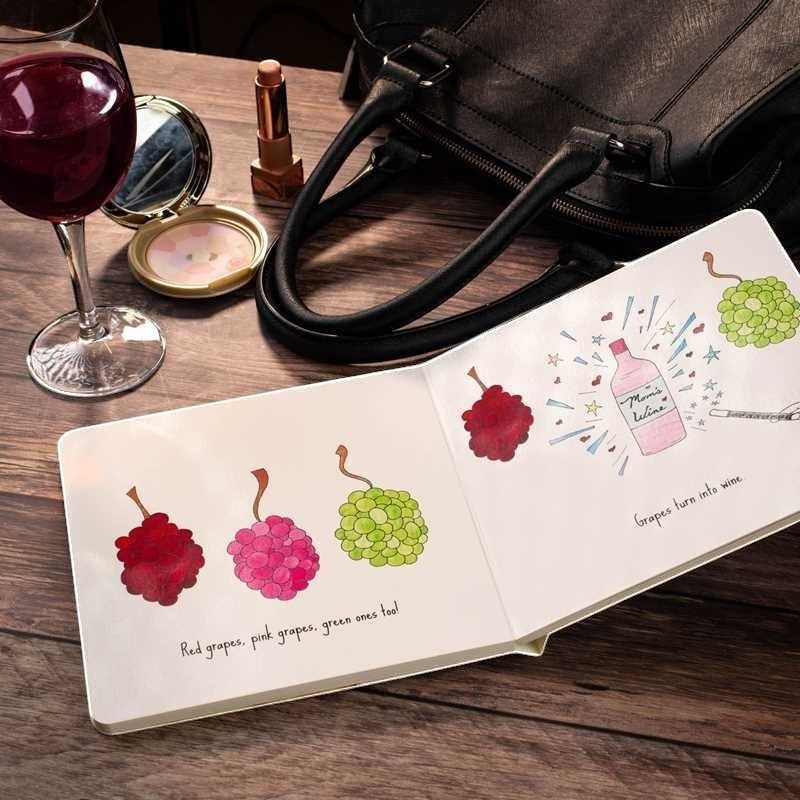 Mellow Monkey Mommy Loves Wine hardcover book with whimsical illustrations of grapes and a wine bottle. Features text about moms enjoying wine.