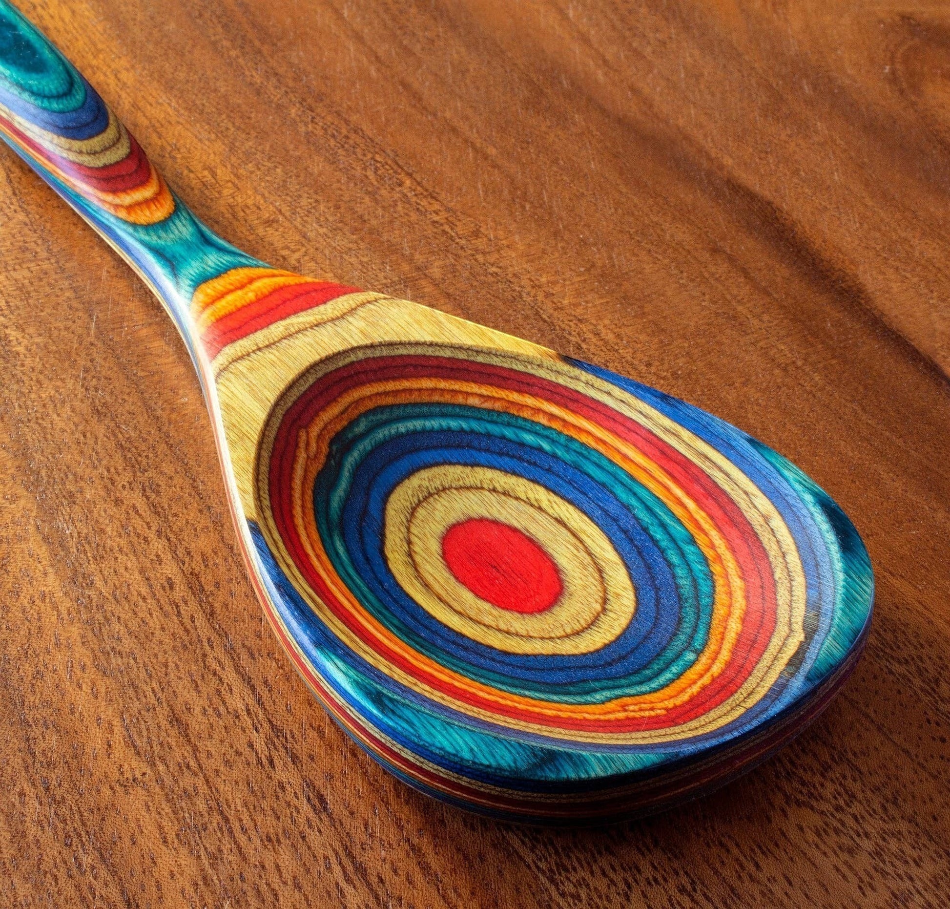Mellow Monkey Montego Bay colorful wooden cooking spoon with teal, blue, red, orange, and yellow layered wood design.