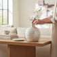 Mellow Monkey 20-inch round bottleneck vase crafted from iridescent mother of pearl mosaic tiles on a wooden table.