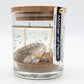 Mellow Monkey Mother of Pearl gel candle with seashells and driftwood scent in a glass jar with a bamboo lid.