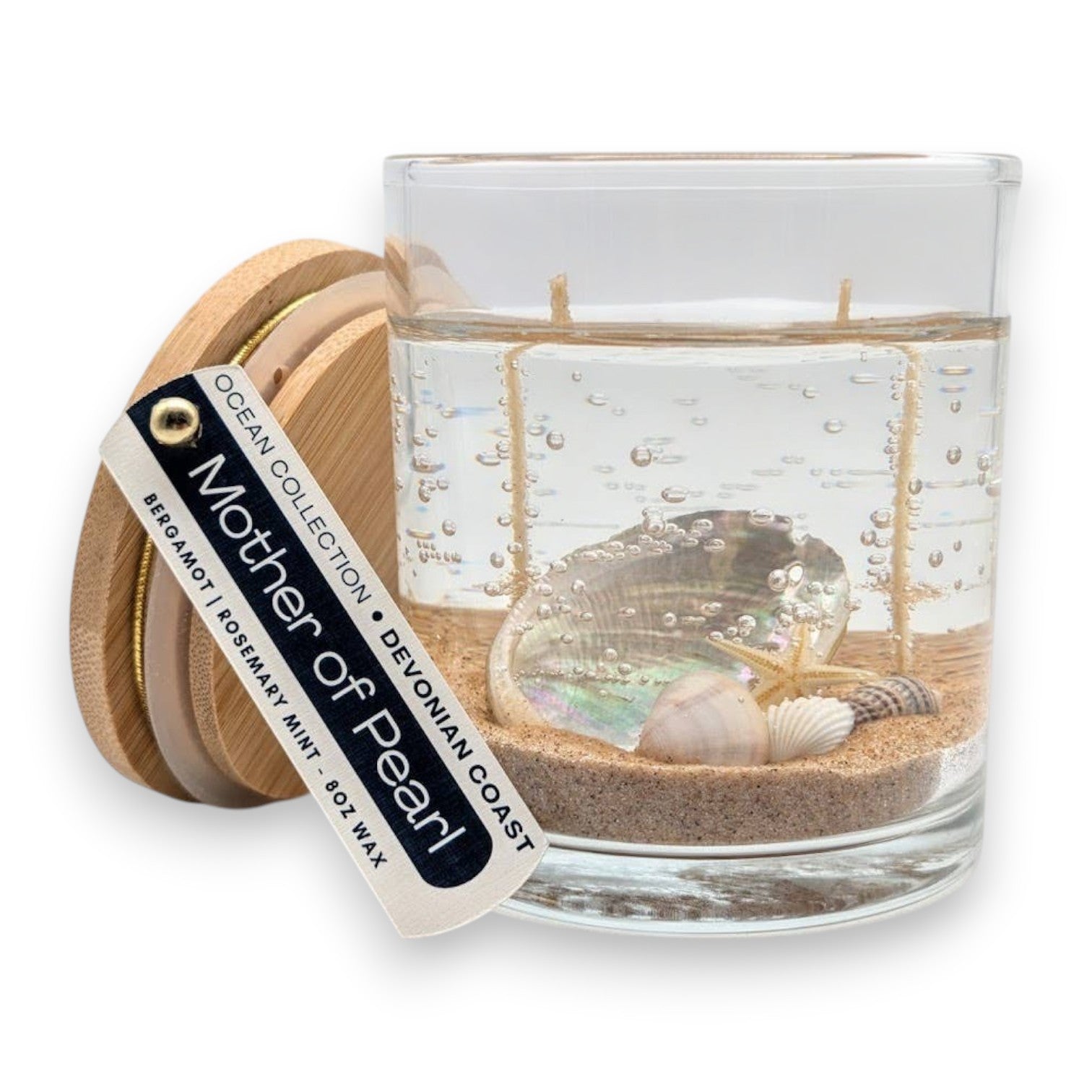 Mellow Monkey Mother of Pearl double wick gel candle with seashells and sand in a glass jar with a wooden lid.