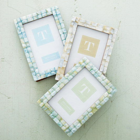 Mellow Monkey mother of pearl tile photo frames in sand, seafoam, and ocean colors on a light textured background.