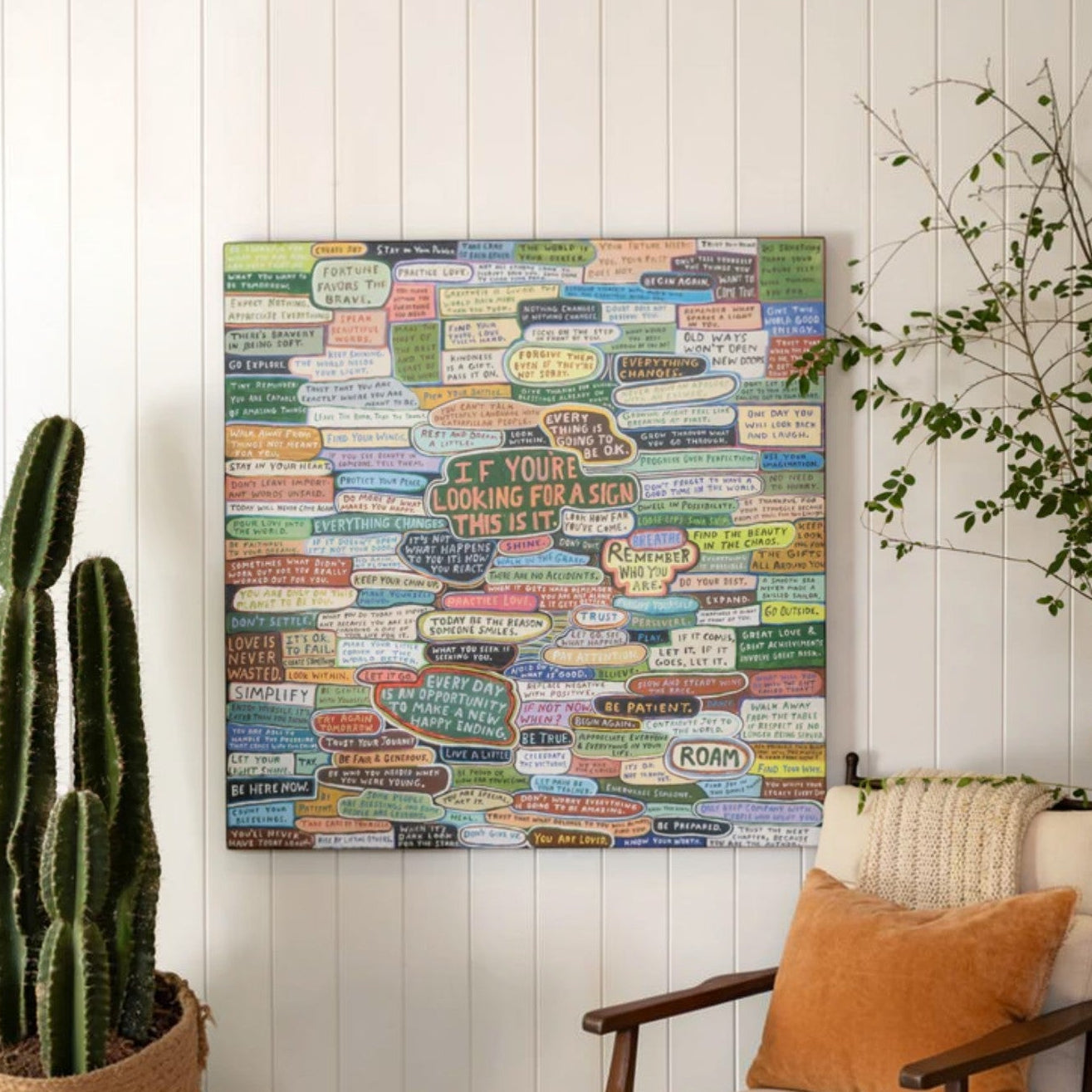 Mellow Monkey gallery wrap wall art featuring colorful motivational quotes on a white wall above a cozy armchair.