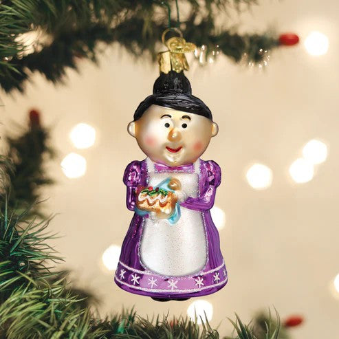 Mellow Monkey Cheery Mrs. Claus blown glass holiday ornament holding a festive cake. Purple dress with white apron.