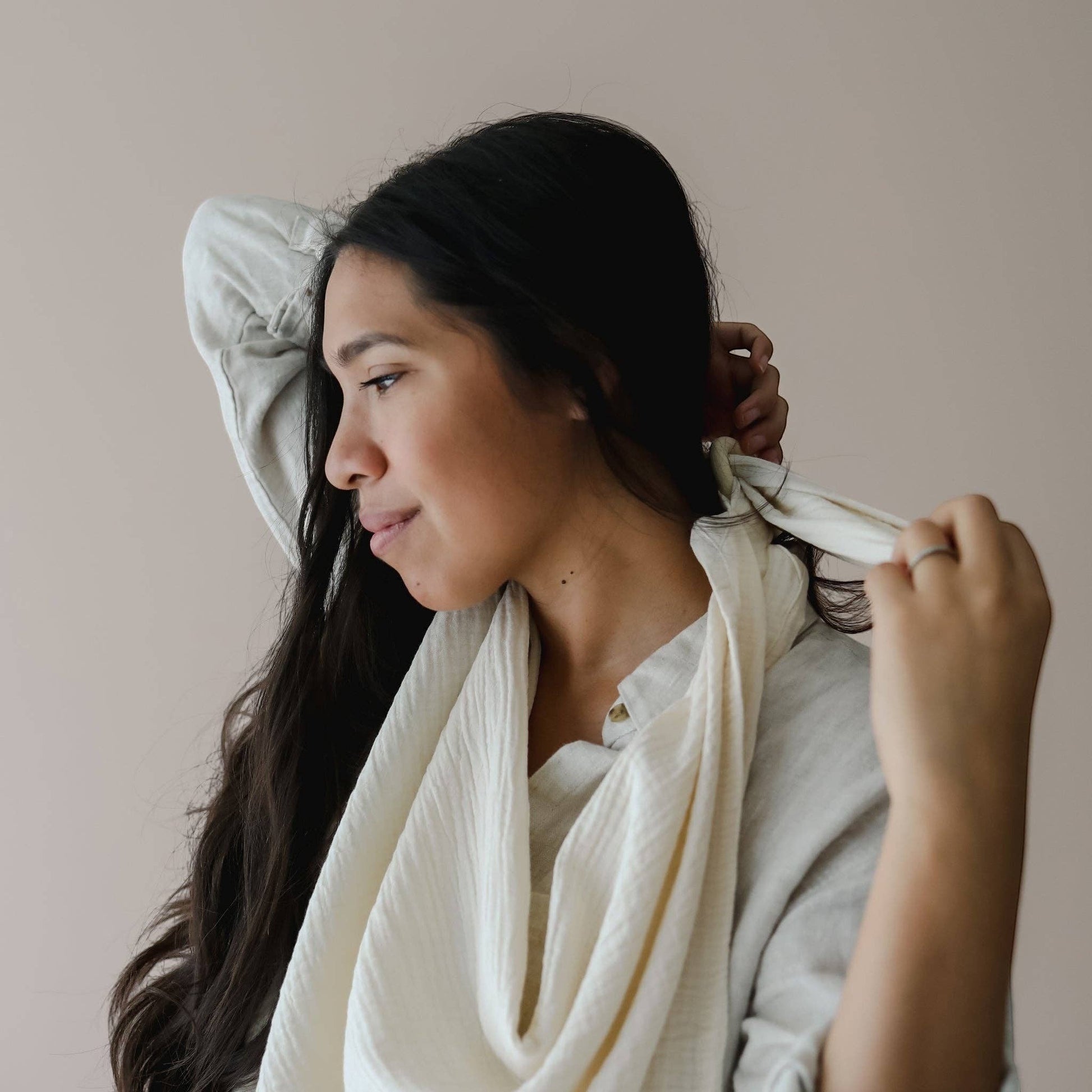 Mellow Monkey natural organic cotton muslin nursing cover with integrated silicone teether worn by a woman.