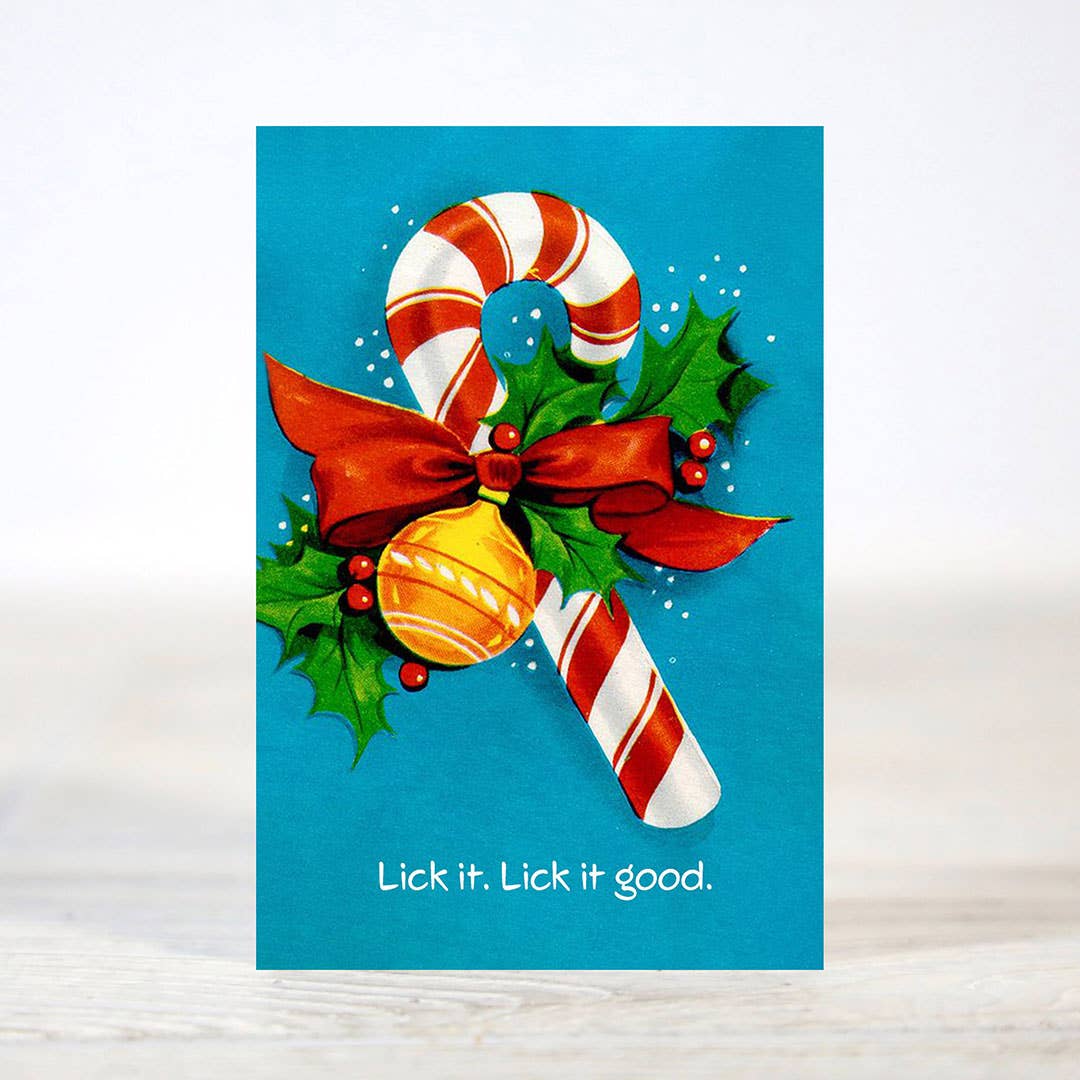 Mellow Monkey mini Christmas card featuring a candy cane, red bow, and holly with the text Lick it. Lick it good.