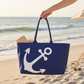 Mellow Monkey navy blue Talia tote bag with white anchor print held by a hand on a sunny beach