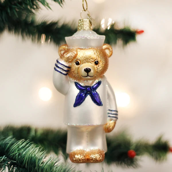 Mellow Monkey Navy Bear blown glass ornament wearing a white sailor uniform and saluting, hanging on a Christmas tree.