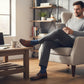 Mellow Monkey navy socks with pixelated middle finger pattern worn by a man in a home office setting.