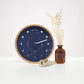 Mellow Monkey navy blue wood marine lunar phase clock with beech frame, white hand, and mineral glass face. Displays moon phases.