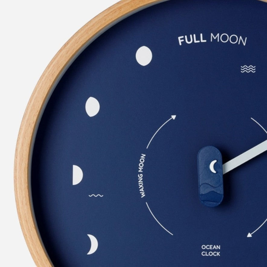Mellow Monkey navy blue wood marine lunar phase clock with a natural beech frame and white hand. Displays moon phases and "FULL MOON" text.