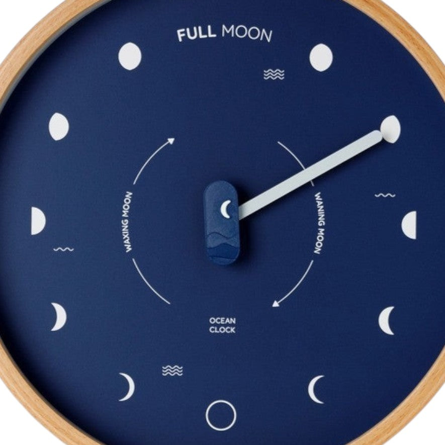 Mellow Monkey navy blue wood marine lunar phase clock with a natural beech frame, white hand, and mineral glass face. Shows moon phases.