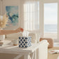Mellow Monkey navy and white patterned paper mache tissue box cover on a white table in a coastal living room.