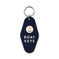 Mellow Monkey navy blue retro motel-style keychain with a sailboat icon and Boat Keys text for coastal decor.