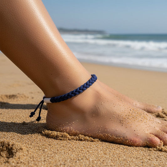 Mellow Monkey navy blue woven cotton nautical anklet worn on a person's ankle at the beach.