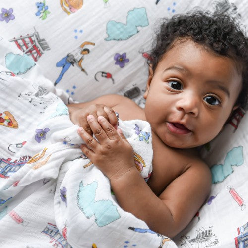 Mellow Monkey baby swaddled in a soft bamboo cotton blanket featuring a colorful New Jersey themed print