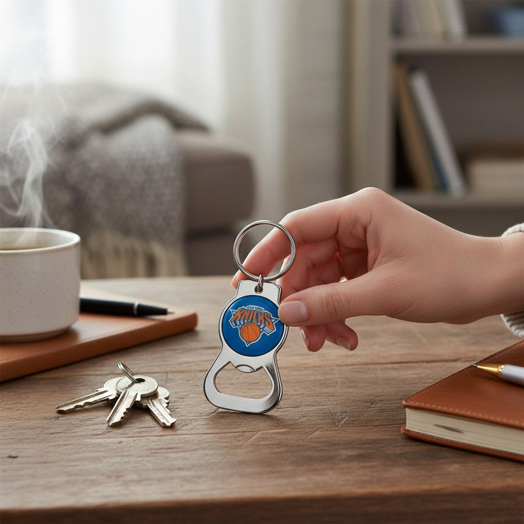 Mellow Monkey NBA New York Knicks metal bottle opener keychain held in hand over a wooden desk with keys