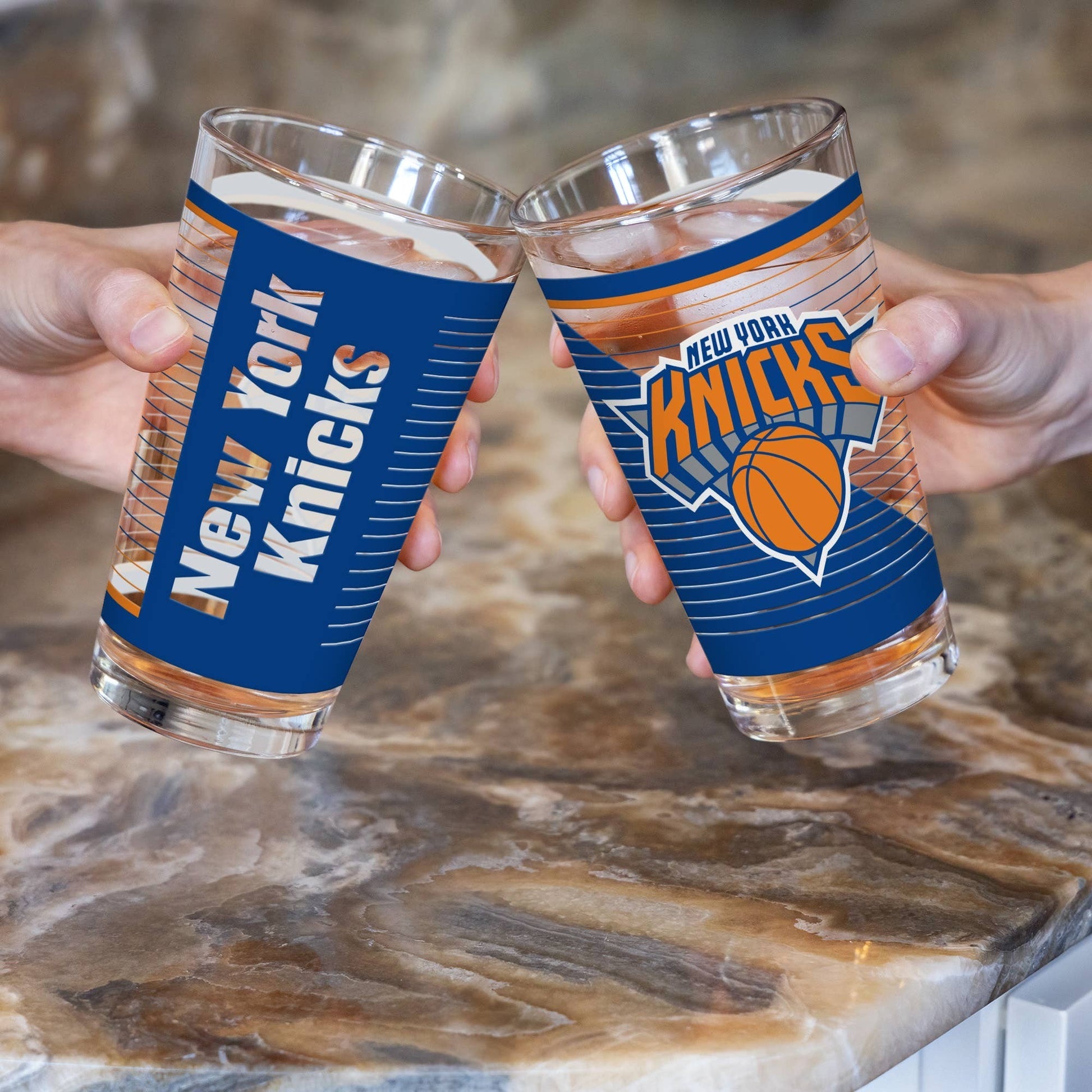 Mellow Monkey New York Knicks 16 oz pint glasses held in a toast with team logo and blue and orange graphics