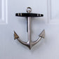Mellow Monkey nickel silver anchor door knocker with black crossbar mounted on a white door for coastal home decor.