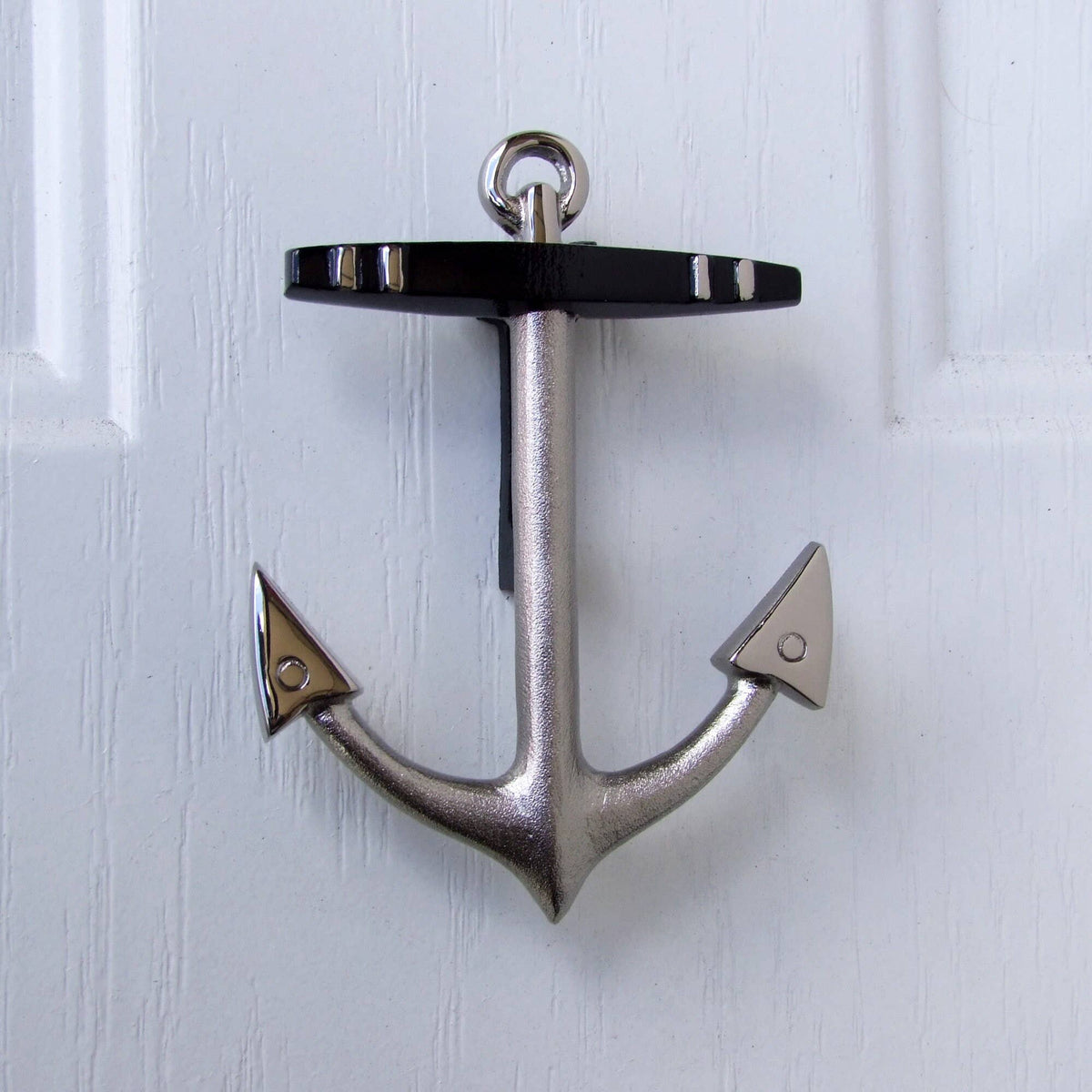 Mellow Monkey nickel silver anchor door knocker with black crossbar mounted on a white door for coastal home decor.