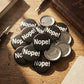 Mellow Monkey 1.25-inch round black pin-back buttons with white Nope! text, featuring a glossy mylar finish.