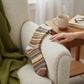 Mellow Monkey Nordic crew socks with a colorful fair isle pattern resting on a cozy cream armchair