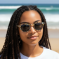 Mellow Monkey Novella Easy Readers with tortoiseshell frames on a woman at the beach, providing UV protection.
