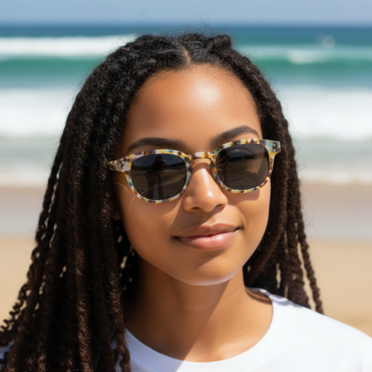 Mellow Monkey Novella Easy Readers with tortoiseshell frames on a woman at the beach, providing UV protection.