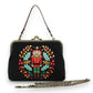 Mellow Monkey black cotton linen kisslock bag featuring a festive embroidered nutcracker and holly wreath design.