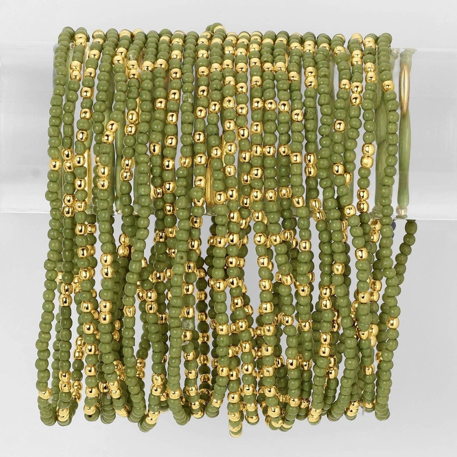 Mellow Monkey olive green seed bead stretch bracelets with 18K gold plated brass accents on a clear display stand.