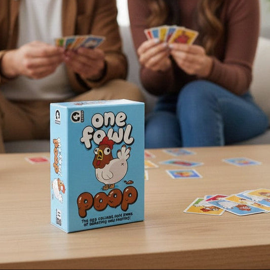 Mellow Monkey One Fowl Poop card game box on a wooden table with a laughing couple playing in the background