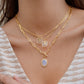Mellow Monkey 18k gold plated necklace with oval opalite pendant and toggle clasp. Features delicate chain and square initial charms.