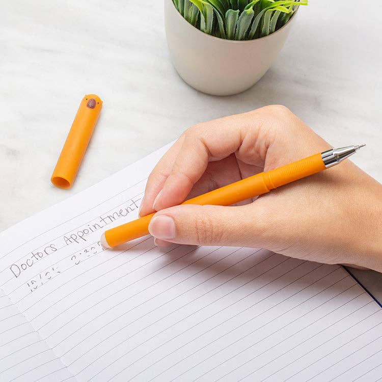 Mellow Monkey orange erasable gel pen with a cute capybara character cap being used to write on lined paper