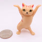 Mellow Monkey 2-inch tall orange tabby dancing cat figurine with arms raised, standing next to a US quarter coin.