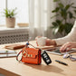 Mellow Monkey orange faux leather mini handbag keychain with gold hardware and colorful scarf detail.