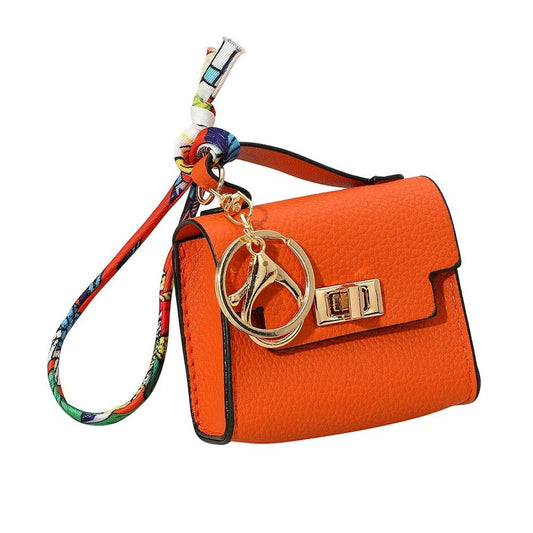 Mellow Monkey miniature orange faux leather handbag keychain with gold clasp and colorful scarf detail.