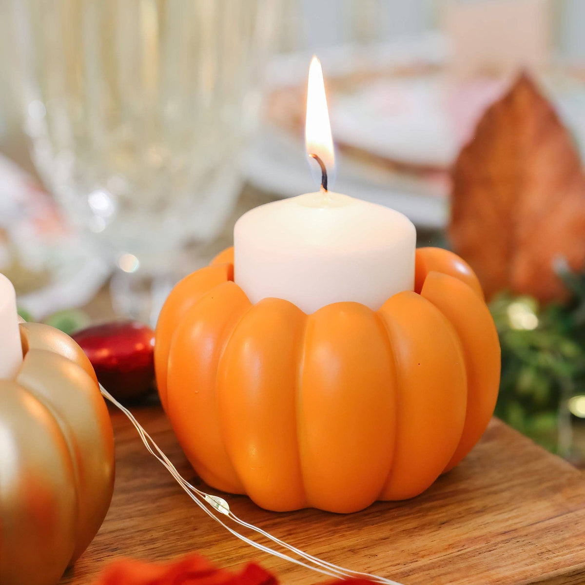 Mellow Monkey set of 6 orange resin pumpkin candle holders holding a white votive candle on a wooden table